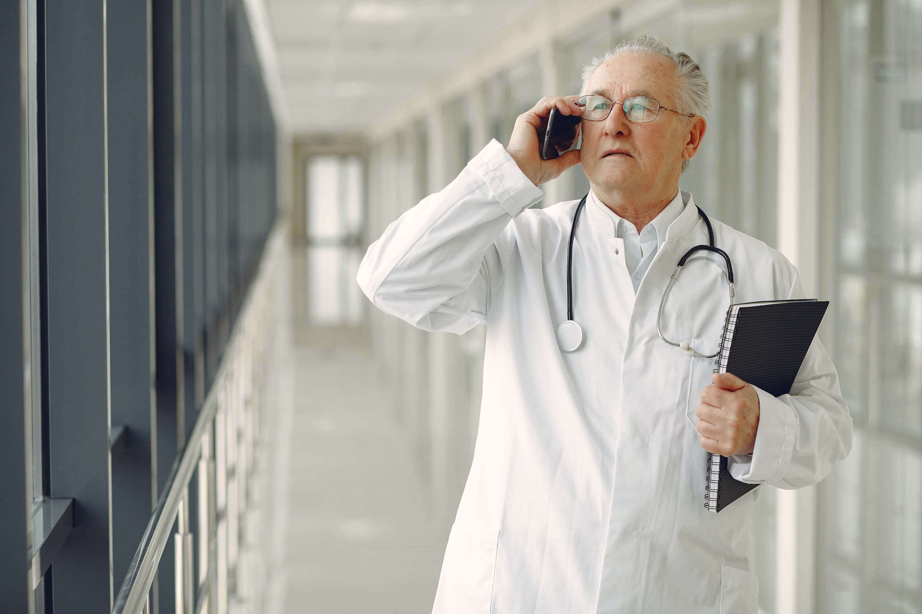  doctor in medical uniform talking on mobile phone in clinic