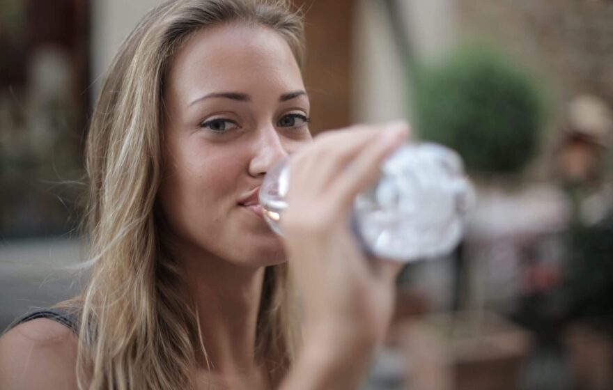 smiling-woman-drinking-water-from-a-plastic-bottle