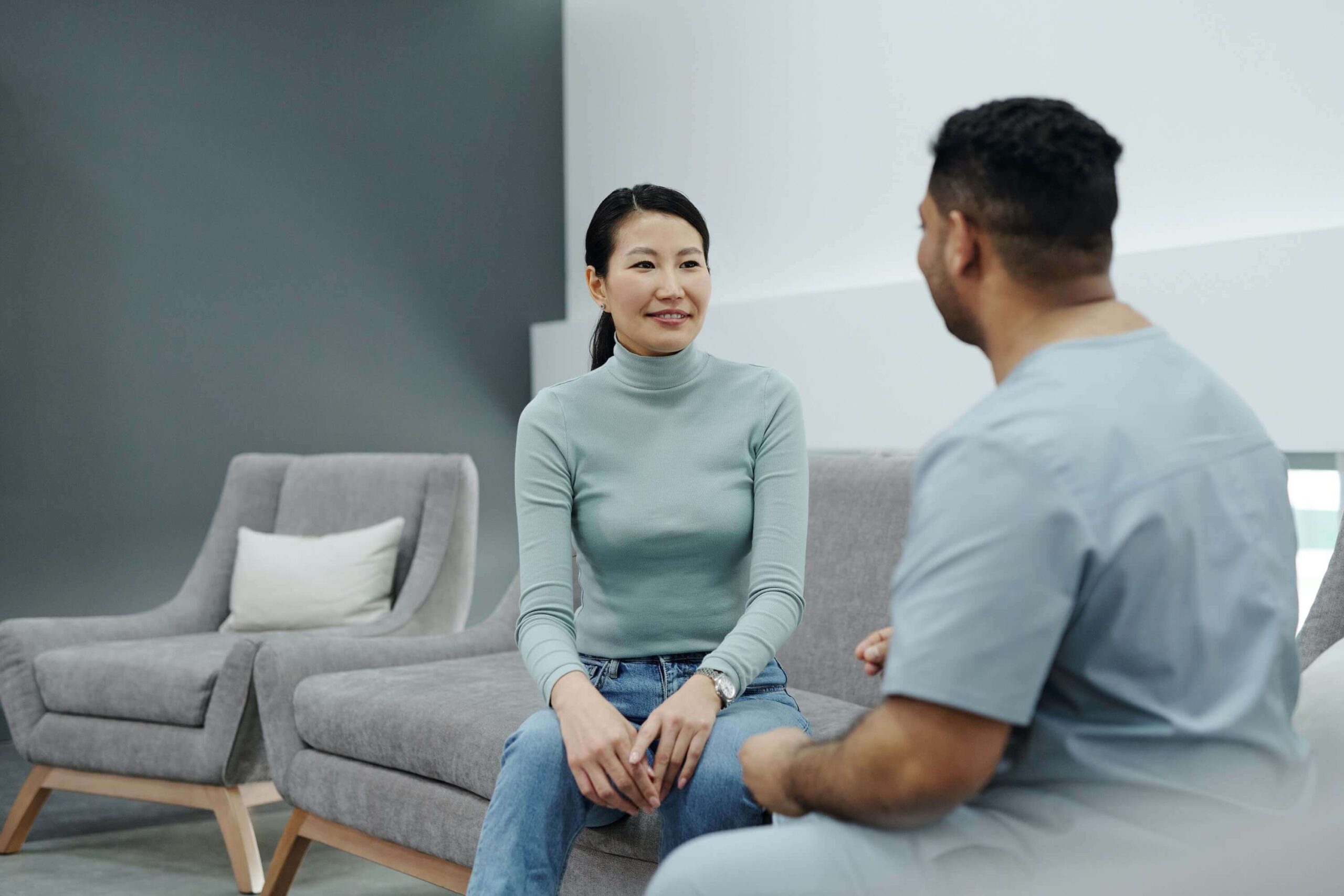 woman and a man sitting on a couch in a clinic