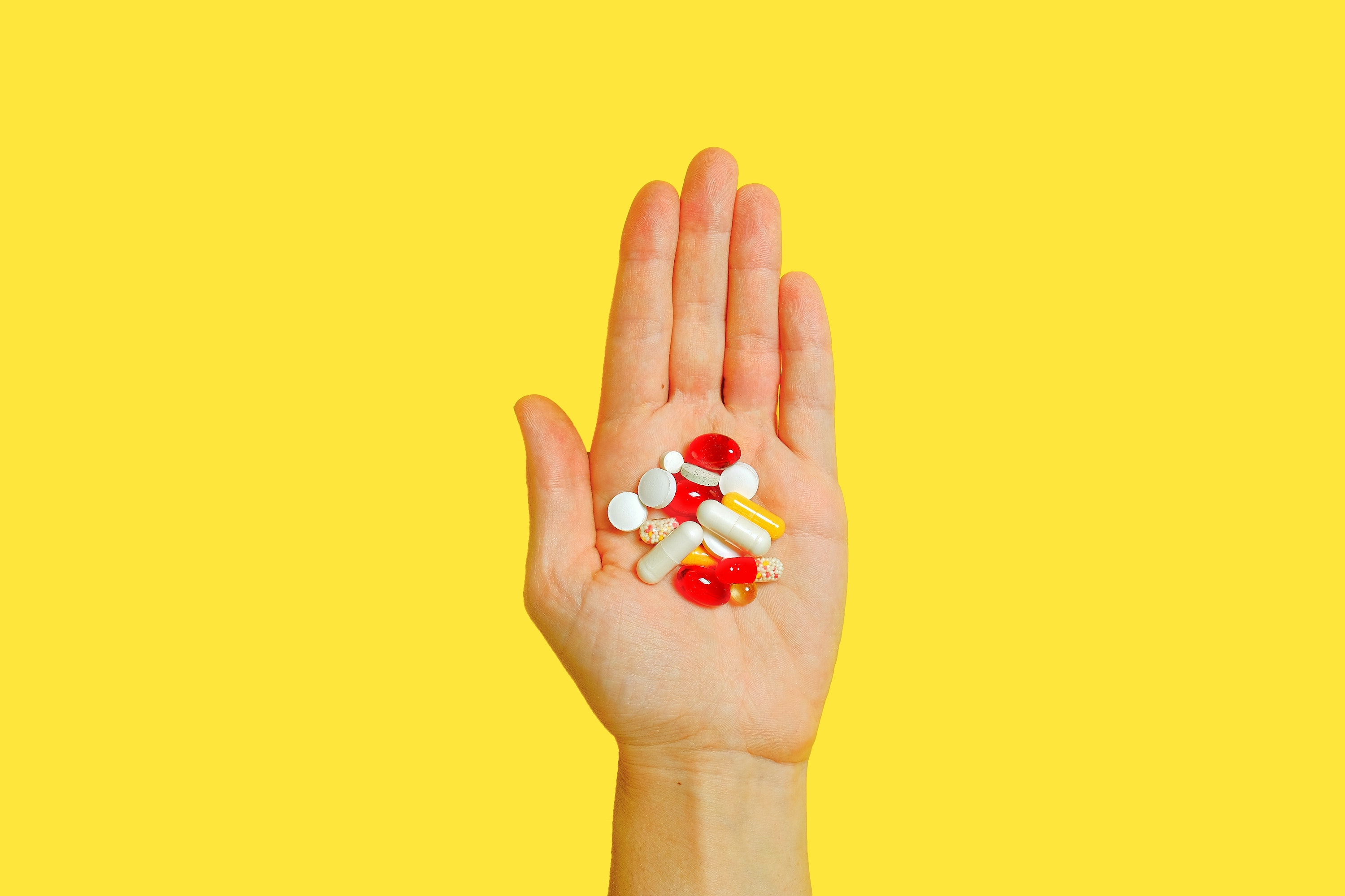 a bunch of vitamin tablets in a hand