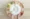 A person holds a white plate with wooden utensils arranged like clock hands, symbolising ways to boost metabolism; the plate rests on a tray with fruit and vegetables arranged in a circle.