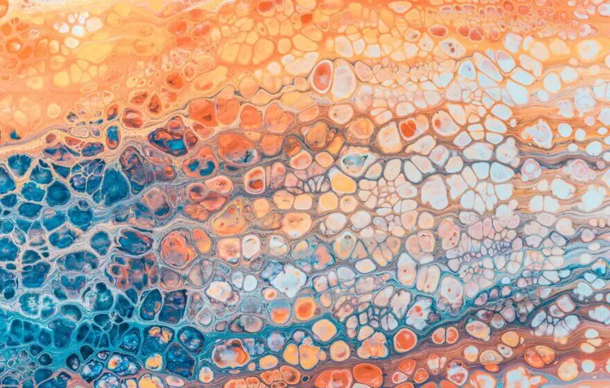 Abstract painting with a honeycomb pattern in blue, orange, and cream colours blending together, evoking an organic effect reminiscent of cells that tackle oxidative stress.