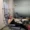 A woman sits in a medical recliner receiving a drip, smiling at the camera in a clinical setting.