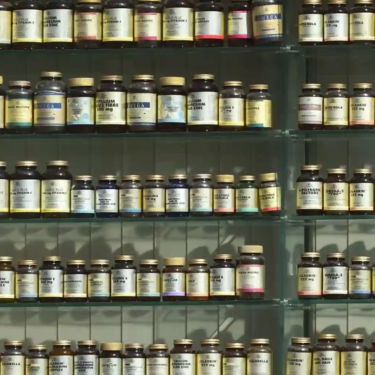 Shelves filled with rows of glass bottles, each labelled with text listing the 7 essential vitamins for boosting your immune system, organised neatly in a well-lit display.
