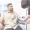 A man sits in a medical chair whilst a healthcare professional wearing gloves prepares to take blood from his arm using a needle and tourniquet, possibly as part of a CRT cell-rejuvenation therapy session.