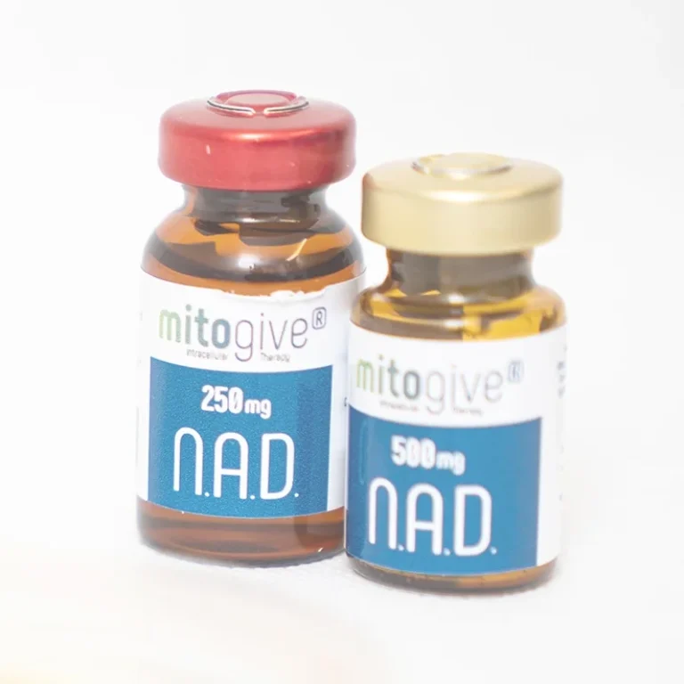 Two glass vials labelled mitogive N.A.D., one with 250 mg and a red cap, the other with 500 mg and a gold cap, contain a yellowish liquid used in NAD+ Anti-Ageing IV Therapy.