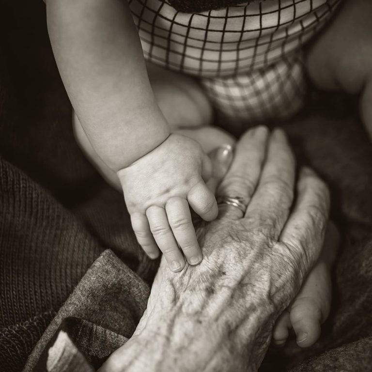 baby holding elder's hand