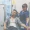 A man sits in a medical chair receiving a Magnesium IV Drip while a nurse in blue scrubs carefully adjusts his IV line.